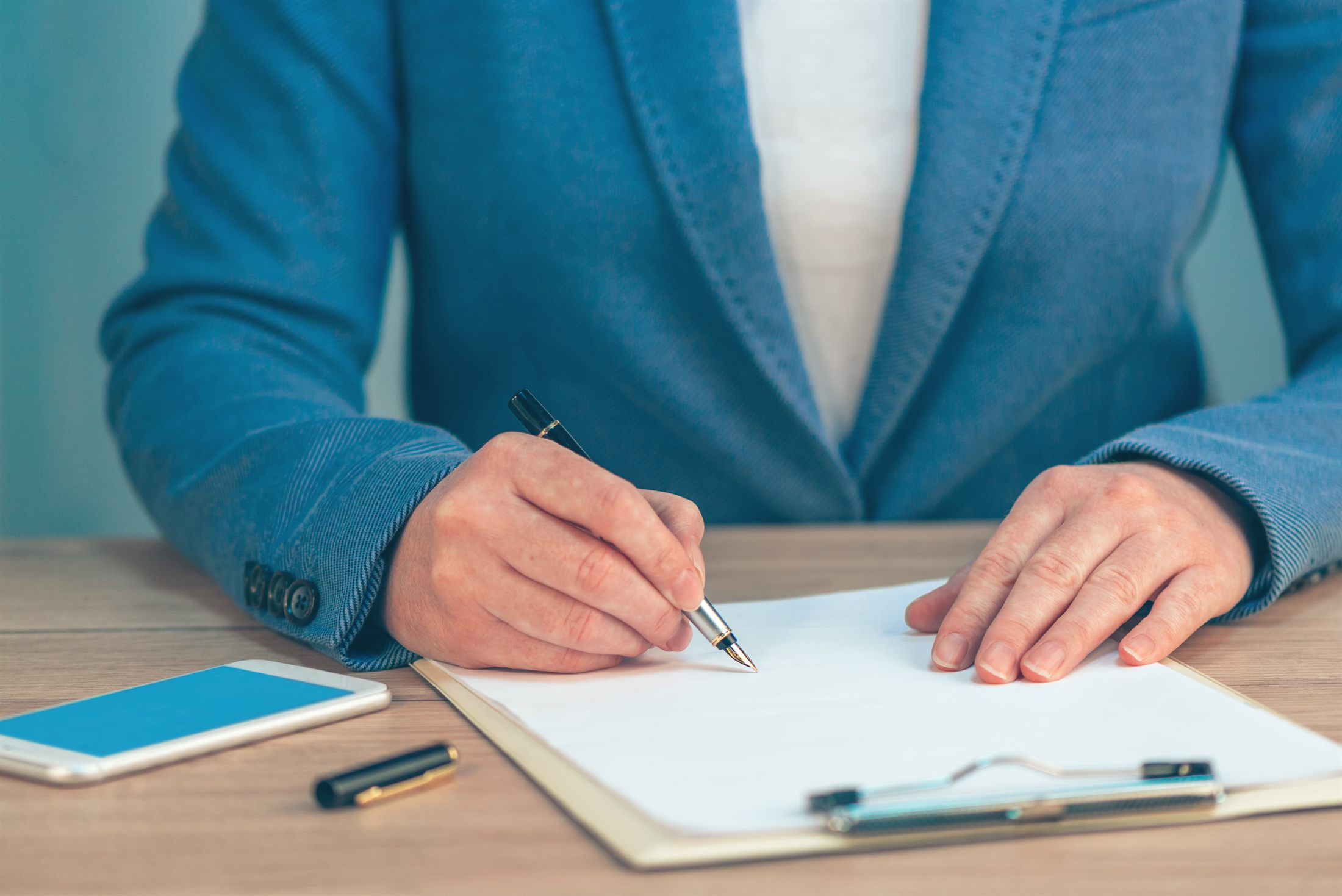 Businesswoman signing a contract at office desk
